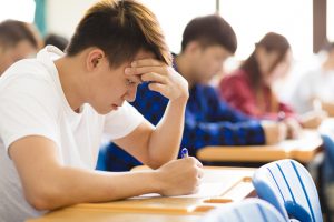Stressed college student for exam in classroom